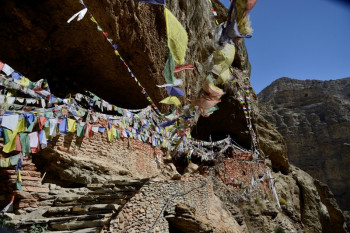 Drapeaux a priéres devant une grotte sacrée En el sitio ARTactif